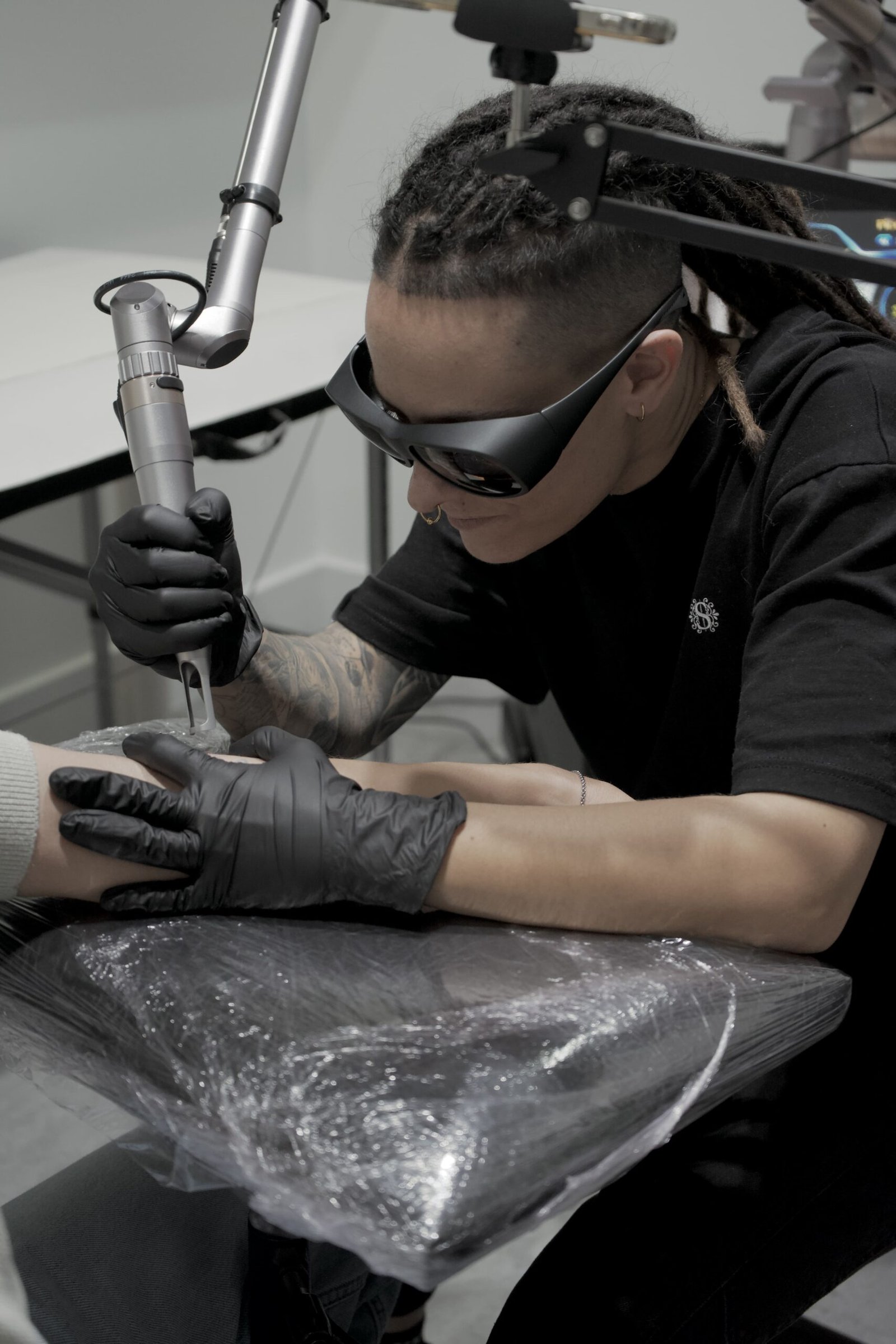 Marina eliminando un tatuaje en el brazo de un cliente en su clinica de Malaga